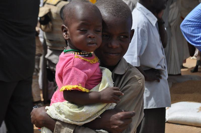 A boy holding a small child in the Abu Shouk camp for displaced people, Darfur
